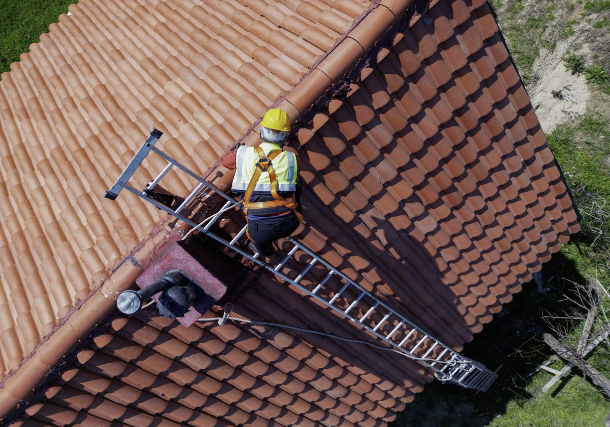 Worker doing roof repair with safety.